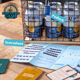 Beer cans in a cage with 'Beer Escape Game' branding, scoresheet, and padlock on a wooden surface.