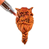 Paint marker being applied to a miniature face with a white background