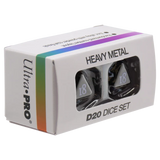 Ultra-Pro Heavy Metal D20 Dice Set in its original white packaging box with a rainbow stripe and clear window showing the black polyhedral dice inside.