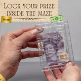 Hand holding a transparent maze with British pound notes inside, against a gray background.