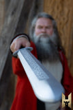 Person in red garment holding a sword with a blurred background