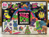 A boxed advent calendar product labeled 'NEEDOH ADVENT' with a colorful illustrated cover showing numbered doors, planets, a rainbow, and cartoon elements. 