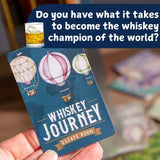 Card with hot air balloons and text about a whiskey escape room, held by a hand.