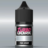 Bottle of Turbo Dork Tin Star paint with black cap on a gray background