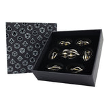 Set of gold and silver dice in a black box with geometric patterned paper.