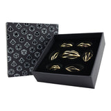 Set of tarnished gold elliptic dice in a black box with geometric pattern