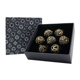 Set of gold decorative dice in a black box with geometric patterned paper