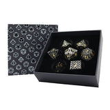 Set of dice with gold and black design in a box with geometric patterned lid.