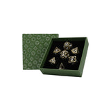 Set of dice with metallic sheen in a green box with geometric pattern