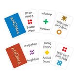 Six Anomia memory cards arranged on a white background, showing both the blue and red textured card backs and several white card faces with examples of 2-letter words, acronyms, wild cards, amphibians, animal sounds, and other symbols.