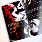 Open book with black and white illustration of an alien-like creature and text.