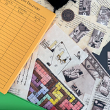 Collection of vintage-style cards and a yellow notepad on a textured surface.