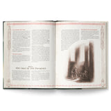 Open book with text and a dark illustration of people in a room.