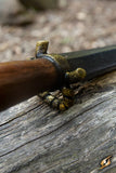 Close-up of a dagger with a wooden handle on a wooden surface