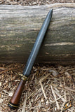 Decorative dagger with wooden handle on a wooden surface