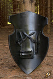Black leather shield with straps against a natural background