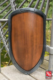 Wooden shield with metal frame on a wooden surface
