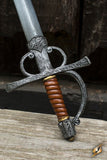 Decorative sword with a wooden handle on a wooden surface