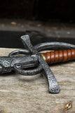 Decorative metal object with leather handle on a wooden surface