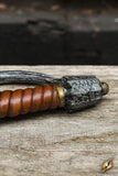 Close-up of a wooden-handled knife with a metallic blade on a wooden surface