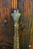 Decorative metal handle on a wooden surface