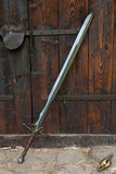 Sword with a wooden handle leaning against a wooden wall.