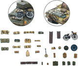 Collection of miniature model components including a motorcycle, tank, and various supplies on a white background.
