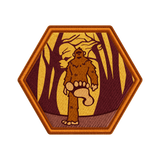 Hexagonal patch with a brown creature in a forest design on a white background