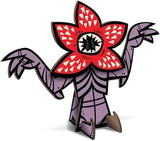 Cartoonish character with a red flower-like head and purple body on a white background