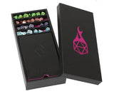 Black dice box with pink logo containing colorful dice