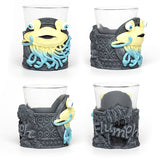 Four glass holders with cartoonish monster designs on a white background