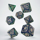 Set of green and blue polyhedral dice with gold numbering on a white background