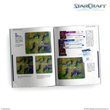 An open book showing printed miniature game materials and reference pages for StarCraft tabletop miniature game, with illustrated terrain scenes and rule sheets on white pages. StarCraft logo appears at top right.