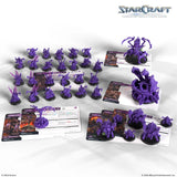 StarCraft game components including purple miniatures and cards on a white background