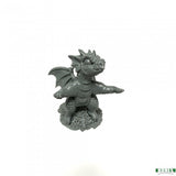 A small unpainted gray fantasy dragon figurine standing on a textured base against a plain white background.