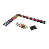 A board game set laid out on a white background, featuring a long printed game board with illustrated tiles, a small instruction booklet, dice, and a black drawstring pouch.