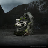 Dragon head sculpture on a stone pedestal with a mountainous background