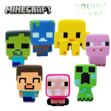 Seven Minecraft character squishy toys arranged on a white background, including Steve, a player, a zombie, a creeper, a pig, a skeleton, and a spider. The Minecraft logo appears at the top left, and 'SQUISH THEM!' is printed at the top right.