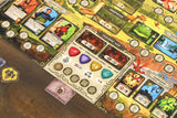 Close-up of a board game with various cards and tokens on a wooden surface