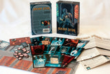 Board game components including cards and boxes on a white surface