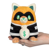 Plush toy raccoon in a prisoner costume holding a money bag with a dollar sign.
