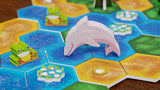 Board game pieces including a dolphin and frog on a colorful hexagonal tile board.