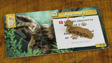 Board game card featuring an anaconda illustration and game instructions on a wooden surface