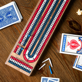 Cribbage board with cards and pegs on a wooden surface