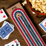 Wooden cribbage board with playing cards and popcorn on a wooden table