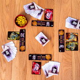 Collection of cards and a bowl of yellow candies on a wooden surface