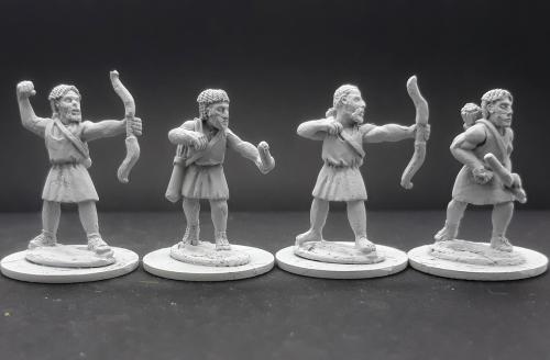 Four miniature figures of warriors on a dark background