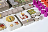 Board game components including cards, tokens, and a character figure on a white surface.