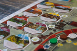 Board game with hexagonal tiles featuring various icons and labels