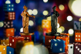Two statues on dice with a colorful, blurred background